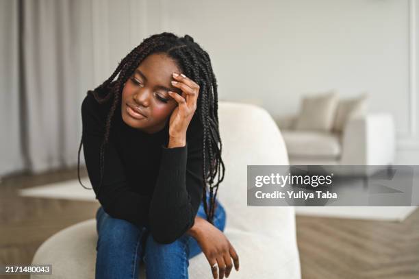 woman looking sad - hand in hair stock pictures, royalty-free photos & images