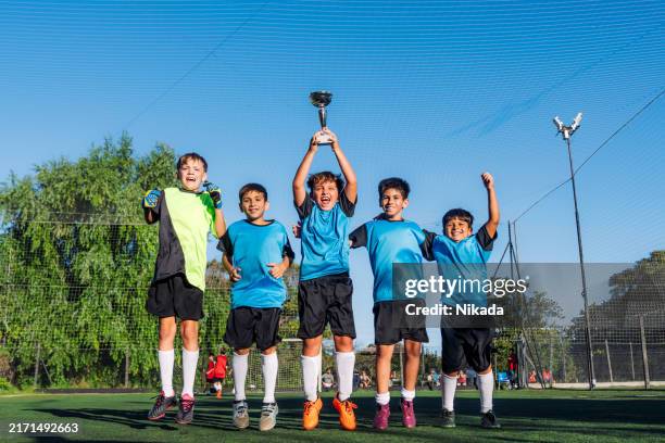 happy group of kids celebrating victory on soccer field - soccer competition stock pictures, royalty-free photos & images