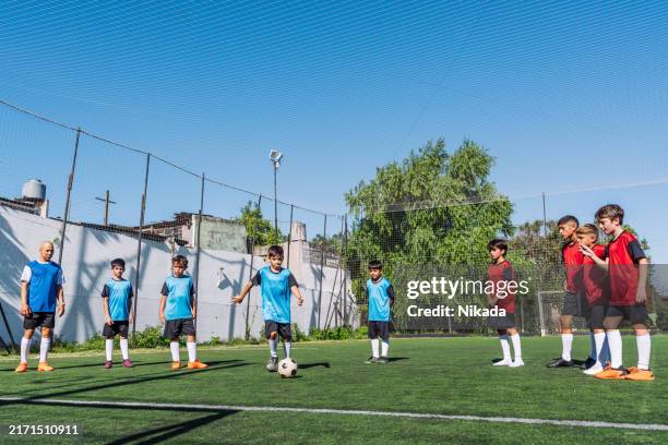 youth soccer players in action on a sunny day at the field - campeonato deportivo juvenil fotografías e imágenes de stock
