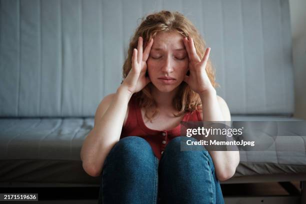 headache and migraine. stressed woman holding head in hands suffering from headache, feeling overwhelmed by life pressure - the morning after stock pictures, royalty-free photos & images
