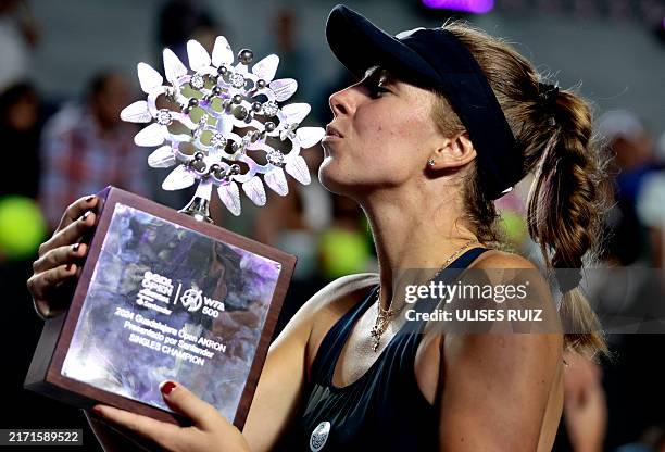 Poland's Magdalena Frech kisses her trophy on the podium after winning the women's singles final of the WTA Guadalajara Open tennis tournament in...