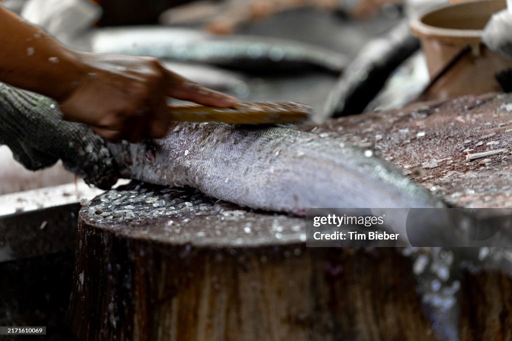 Scaling a fish in the market.