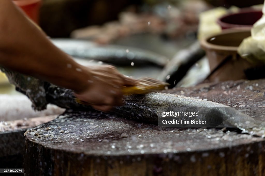Scaling a fish in the market.