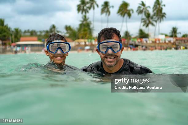 father and son wearing a diving mask on the beach - scuba mask stock pictures, royalty-free photos & images