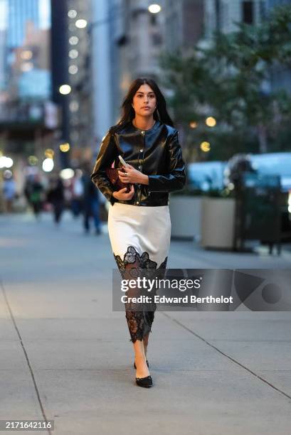 Guest wears shiny black cardigan, white and black sheer mesh lace midi skirt, black ballerina flats leather shoes, black leather bag, silver...