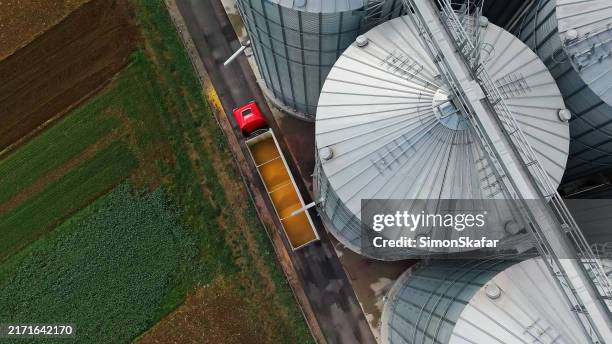 vue aérienne du transfert du maïs du silo au camion - usine agro alimentaire photos et images de collection