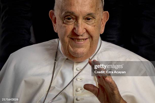 Pope Francis waves to well wishers as he leaves following an interreligious dialogue with the youth at the Catholic Junior College on September 13,...