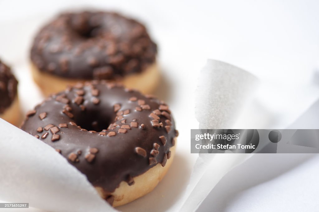 白い紙にアイシングとストライプのドーナツ2個。