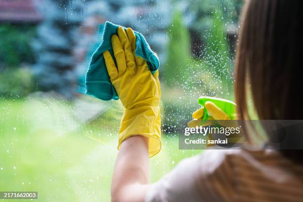 femme méconnaissable nettoyant les fenêtres d’une maison de campagne - gant-de-ménage photos et images de collection