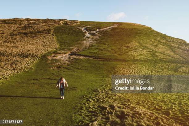 young woman walking on seven sister's cliffs in the uk - seven sisters klif stockfoto's en -beelden