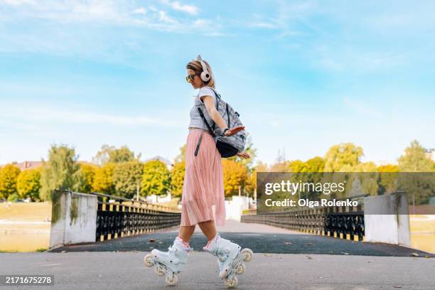heel toe rolling tricks for beginners in park. woman practicing activity on waterfront - rollschuhlaufen stock-fotos und bilder