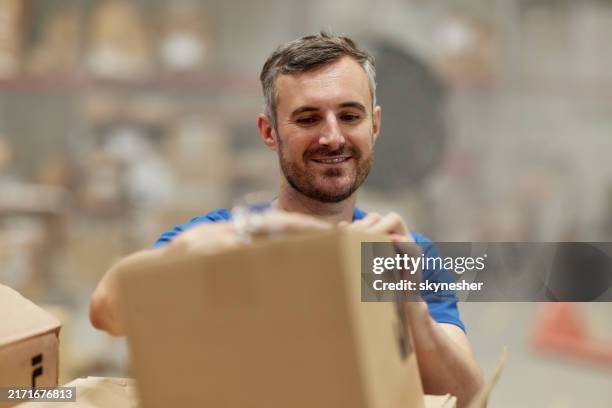 happy warehouse worker working with a package in storage room. - storage compartment stock pictures, royalty-free photos & images