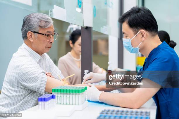 blood test for asian elderly couple during physical examination - hematology stock pictures, royalty-free photos & images