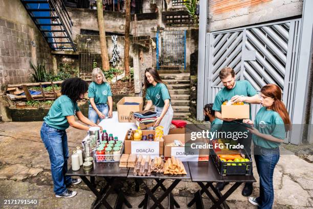 volunteers arranging items for donation outdoors - food distribution stock pictures, royalty-free photos & images