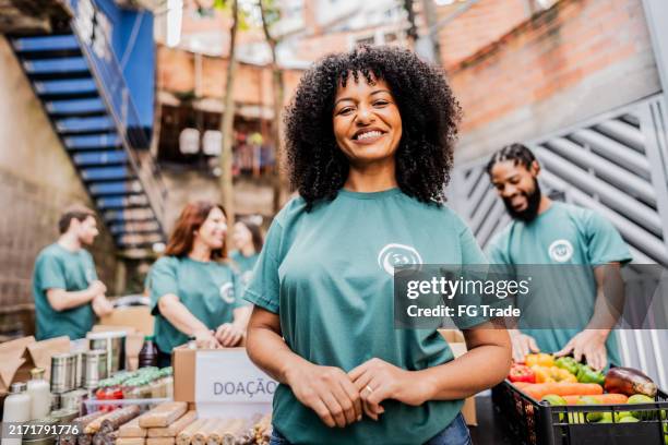 retrato de una mujer voluntaria adulta mediana durante un evento de donación al aire libre - favela fotografías e imágenes de stock