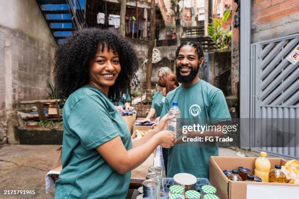 portrait of volunteers during donation event outdoors - charity stock pictures, royalty-free photos & images