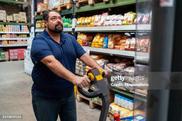 employee using a forklift while restocking shelves at the supermarket - grocery store worker restocking shelves stock pictures, royalty-free photos & images