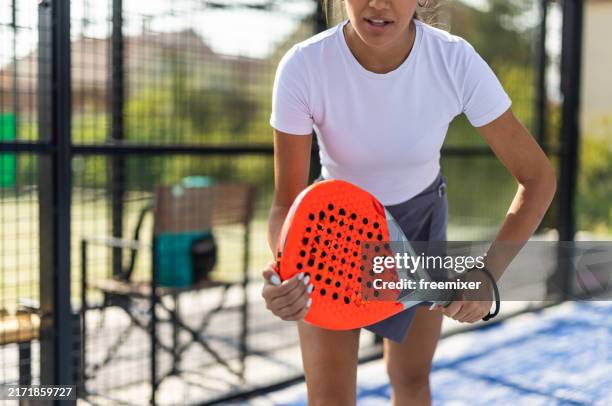 young woman playing paddle tennis on outdoor court - paddle ball stock pictures, royalty-free photos & images
