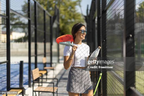 female paddle tennis player arriving to court - racquet stock pictures, royalty-free photos & images