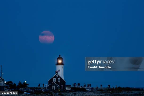 The harvest moon, a full supermoon, rises over Scituate Light in Scituate, Massachusetts, United States on September 17, 2024.
