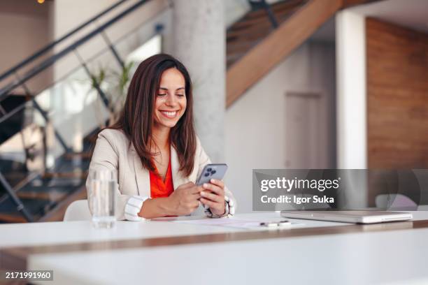 la mujer de negocios sonríe y usa el teléfono, la comunicación o la lectura en la oficina. planificadora de eventos de empleada feliz que revisa el correo electrónico, las redes sociales o la publicación en el teléfono inteligente y la computadora en - organizador de eventos fotografías e imágenes de stock