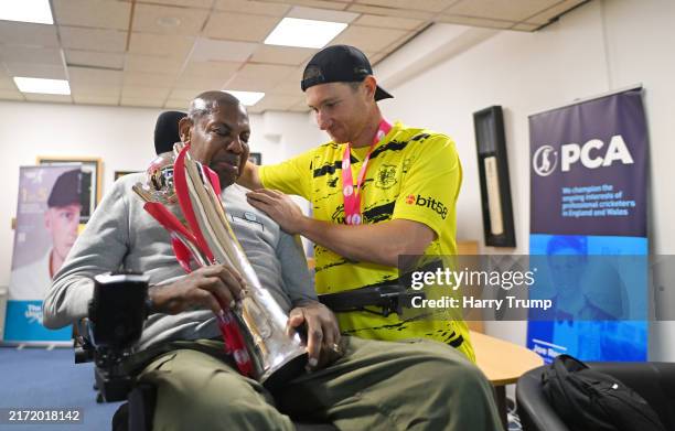 James Bracey of Gloucestershire interacts with Syd Lawrence and the T20 Vitality Blast Trophy following the T20 Vitality Blast Final match between...