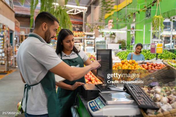 business manager training a new employee at the supermarket - cashier stock pictures, royalty-free photos & images