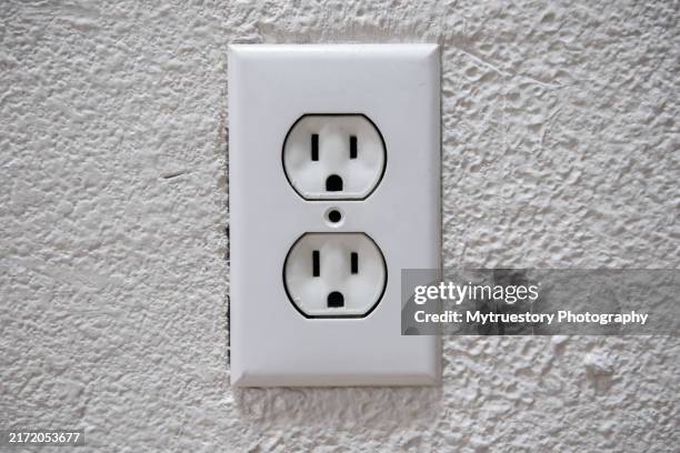 an american 110 volt three prong electrical power outlet isolated on white wall. - prise électrique photos et images de collection