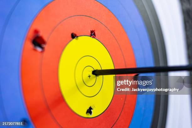archery target with arrows in the bullseye - dartboard stock pictures, royalty-free photos & images