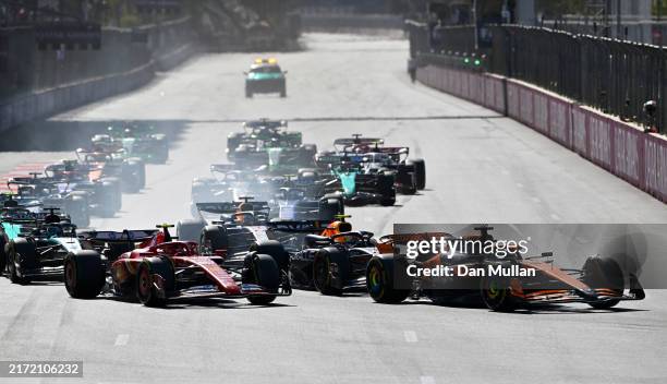 Oscar Piastri of Australia driving the McLaren MCL38 Mercedes leads Sergio Perez of Mexico driving the Oracle Red Bull Racing RB20 and Carlos Sainz...