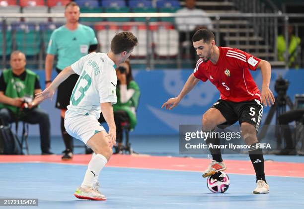Suliman Aldrwlsh of Libya controls the ball under pressure from Oban Hawkins of New Zealand during the FIFA Futsal World Cup Uzbekistan 2024 match...