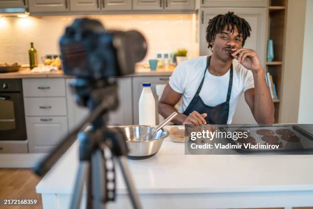 cooking for the camera, and tasting the food - bakplåt bildbanksfoton och bilder