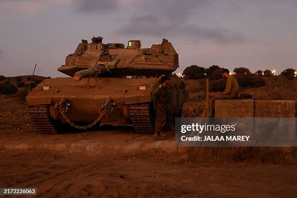 Israeli soldiers gather near a tank in the Israeli-annexed Golan Heights on September 19, 2024.