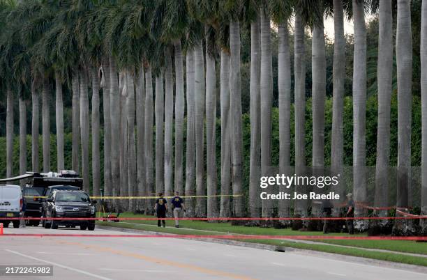 Law enforcement personnel investigate the area around Trump International Golf Club after an apparent assassination attempt of former President...