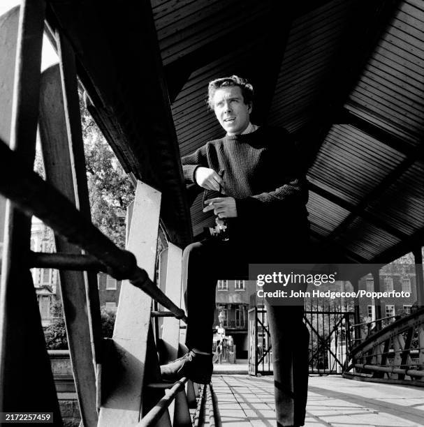 English photographer Antony Armstrong-Jones standing with his camera on a jetty over the River Thames in London, England circa 1958. Armstrong-Jones...