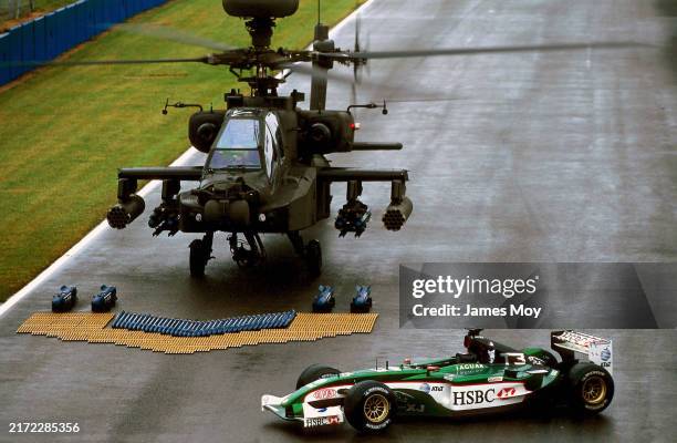 An Agusta Westland Apache British Army Helicopter arrives on the start/finish line with a Terminator 3 liveried Jaguar R4 beside it. British Grand...