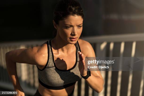 athletic woman running outdoors in the morning. - athlete stock pictures, royalty-free photos & images