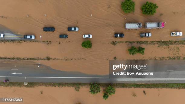 aerial view of cars driving on flooded road after typhoon yagi swept across thailand. - phénomène climatique extrême photos et images de collection