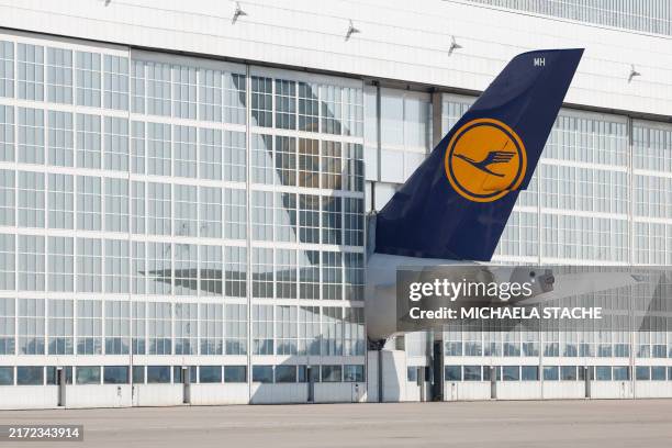 The tale of a Lufthansa airplane sticks out of a hangar at the Franz Josef Strauss airport in Munich, southern Germany, on September 20, 2024.