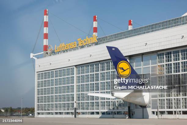 The tale of a Lufthansa airplane sticks out of a hangar at the Franz Josef Strauss airport in Munich, southern Germany, on September 20, 2024.