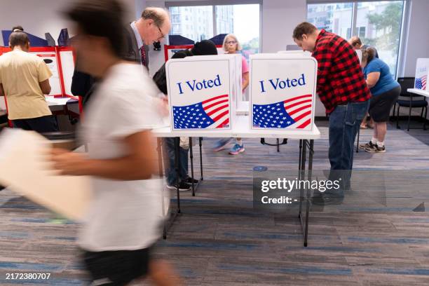 Voters work on their ballot at a polling station at the Elena Bozeman Government Center in Arlington, Virginia, on September 20, 2024. Early...