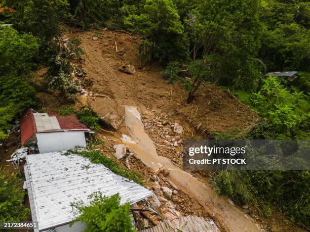 aerial view landslide impacting hillside village in dense forest - aardverschuiving stockfoto's en -beelden