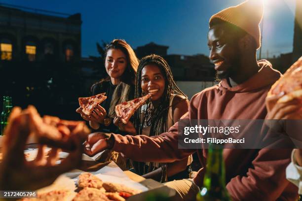 friends are dining together with pizza - rooftop dining stock pictures, royalty-free photos & images