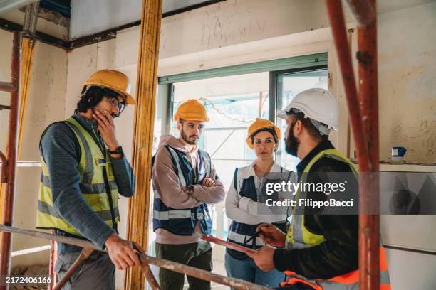 a man is explaining the project to three workers / students - apprentice builder stock pictures, royalty-free photos & images