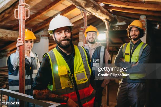 portrait d’une équipe de travailleurs de la construction regardant la caméra sur un chantier de construction - maçon photos et images de collection