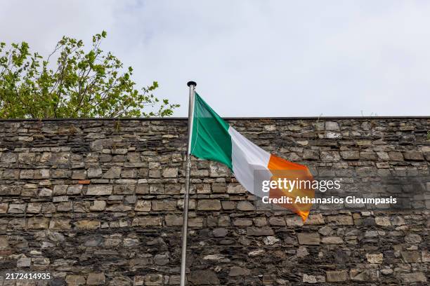 The Irish flag at Kilmainham Gaol Museum on August 17, 2024 in Dublin, Ireland. Kilmainham Gaol opened in 1796 and was closed in 1924 and preserved...