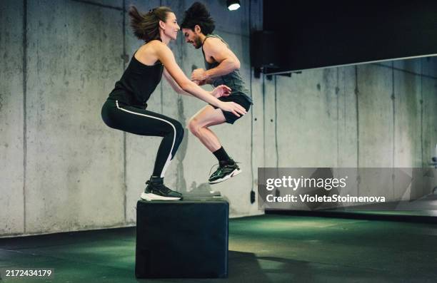 couple doing intense workout session at health club. - jump squat exercise bildbanksfoton och bilder