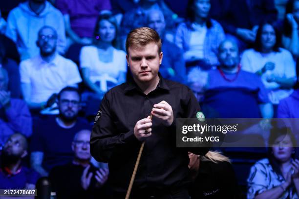 Aaron Hill of Ireland chalks the cue in the first round match against Mark Selby of England on day 1 of 2024 BetVictor English Open at the Brentwood...