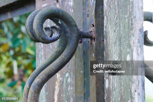 wrought iron on the wood fence - old abandoned mansions stock pictures, royalty-free photos & images