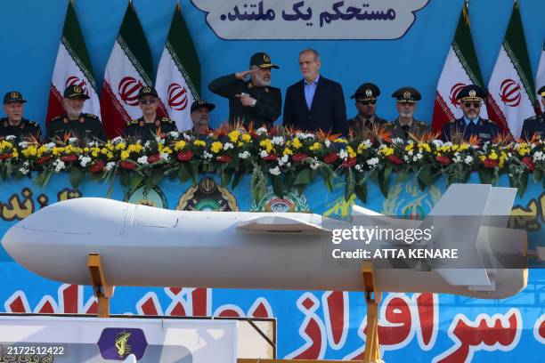Iranian President Masoud Pezeshkian and commander of the Islamic Revolutionary Guard Corps' Aerospace Force Amir Ali Hajizadeh look on as Iran's new...